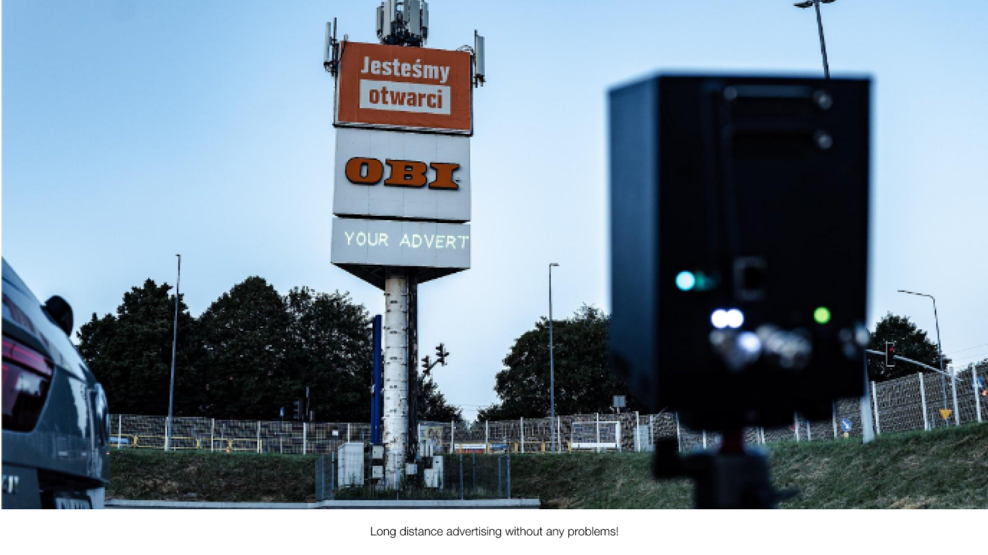 A large signage outdoor with the text "your advert" projected onto it from a Lasercube laser projector, showcasing how it can be used for outdoor advertising