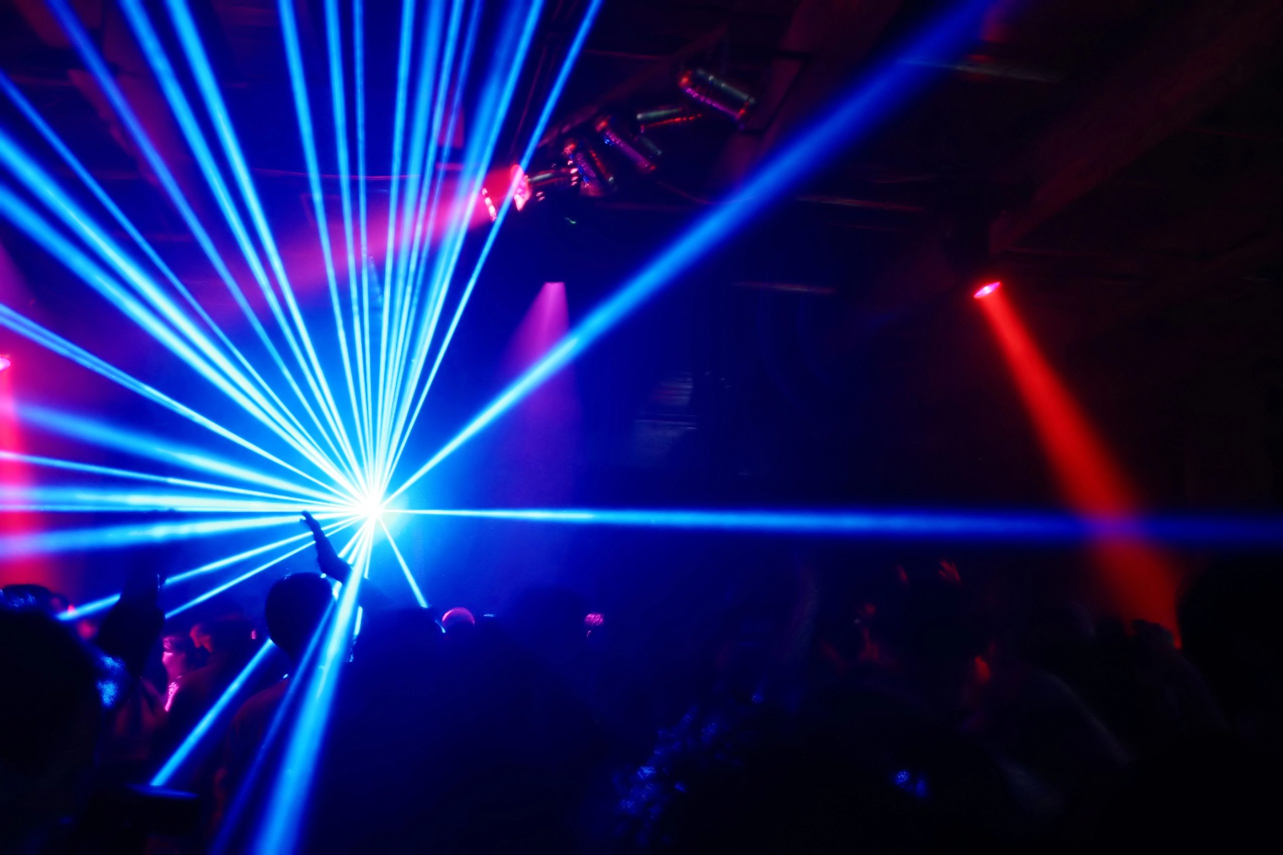 blue laser light projected from a laser projector at a disco party